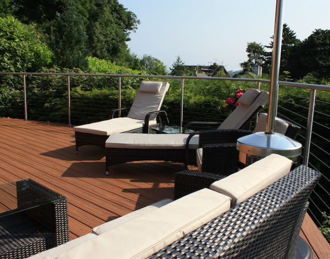 Terrasse en bois avec garde-corps, aménagée avec un salon de jardin