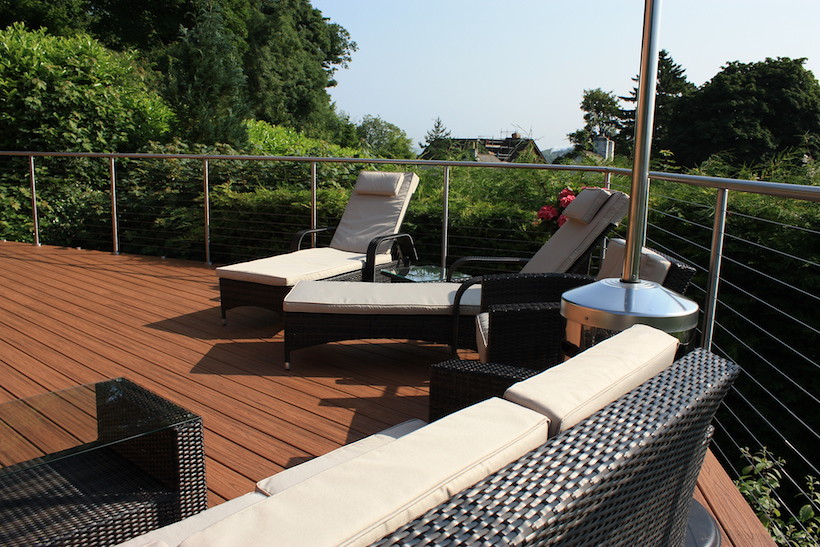 Terrasse en bois avec garde-corps, aménagée avec un salon de jardin
